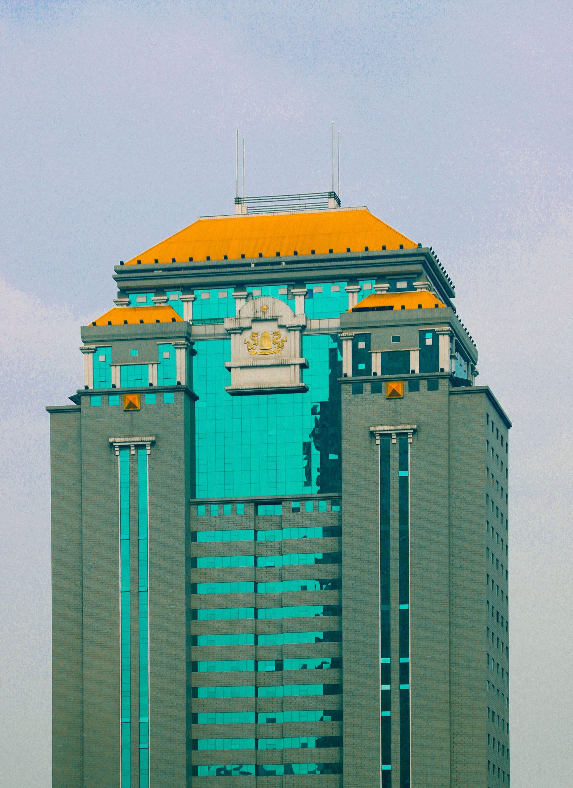 A modern skyscraper with bold architectural design and vibrant rooftop colors.